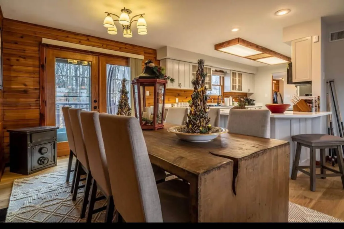 This shot showcases a wooden dining table with decorative centerpieces, set near French doors that let in ample light. The setting is perfect for hosting family meals and gatherings in a warm, inviting environment.